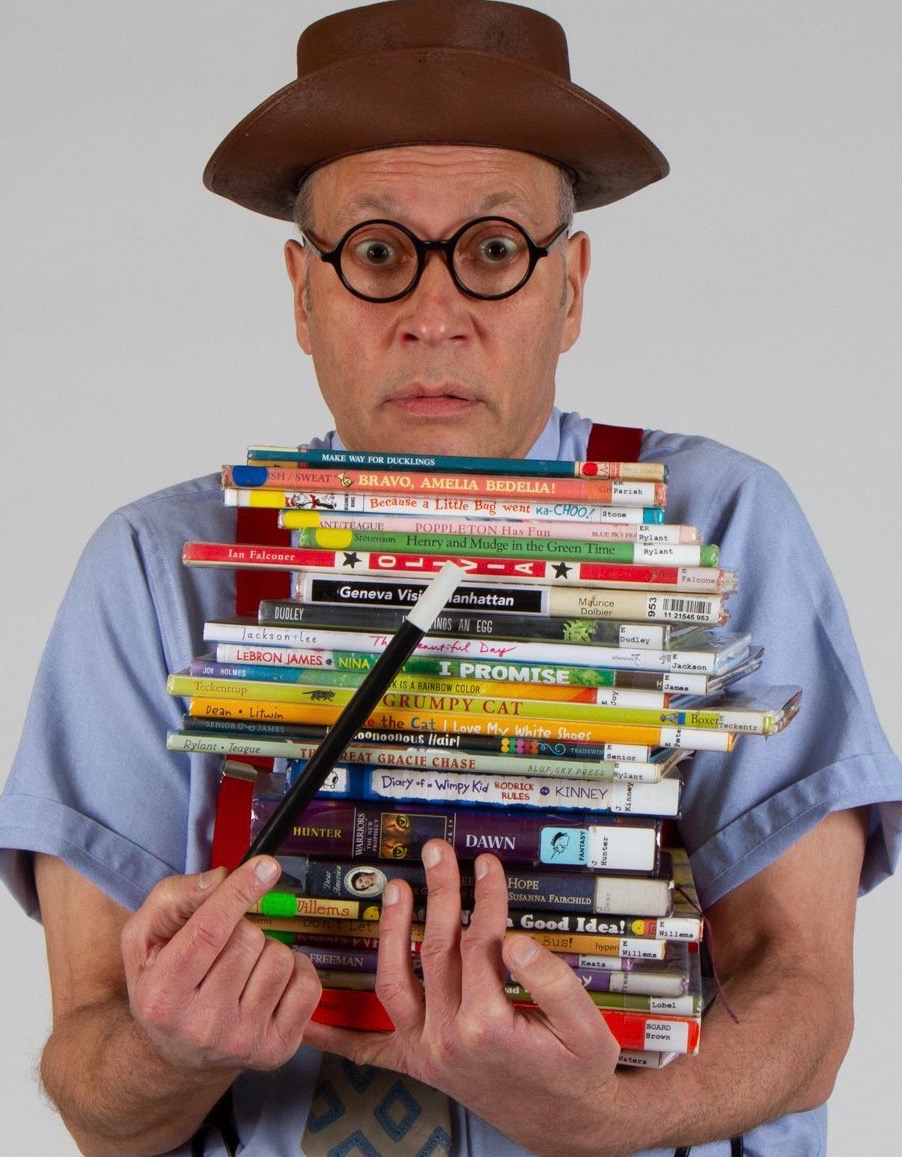 David Moreland the magician holding a stack of books